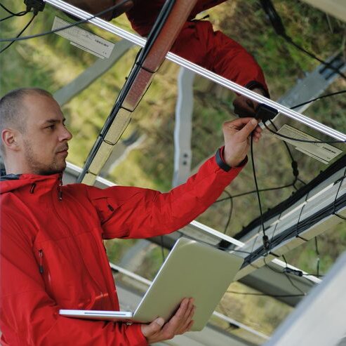 engineer-using-laptop-solar-panels-plant-field_1078540-10089